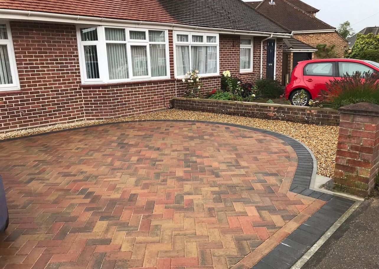 A perfectly laid block paving driveway curving up to a Kent country home at golden hour